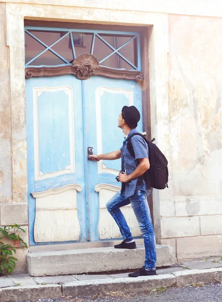 Homem de pé contra a velha porta azul — Fotografia de Stock