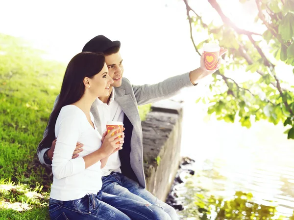 Jonge gelukkige paar zitten in park — Stockfoto