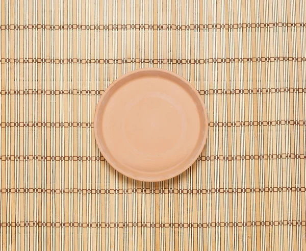 Пустая тарелка на бамбуковом коврике — стоковое фото