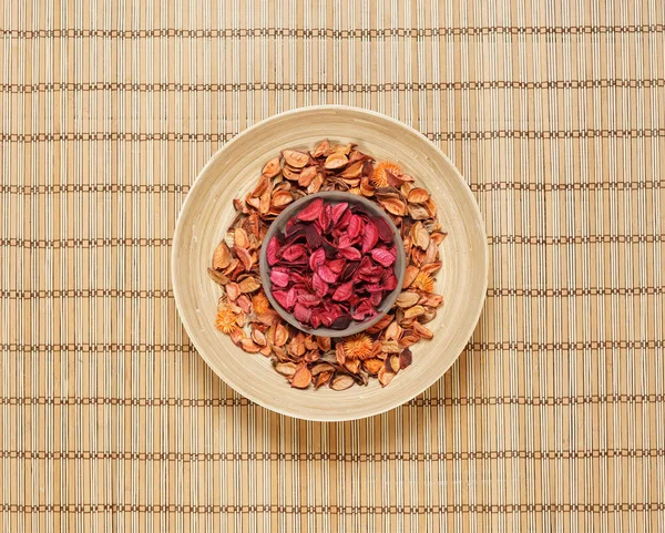 Placa com pétalas de aroma no tapete de bambu — Fotografia de Stock