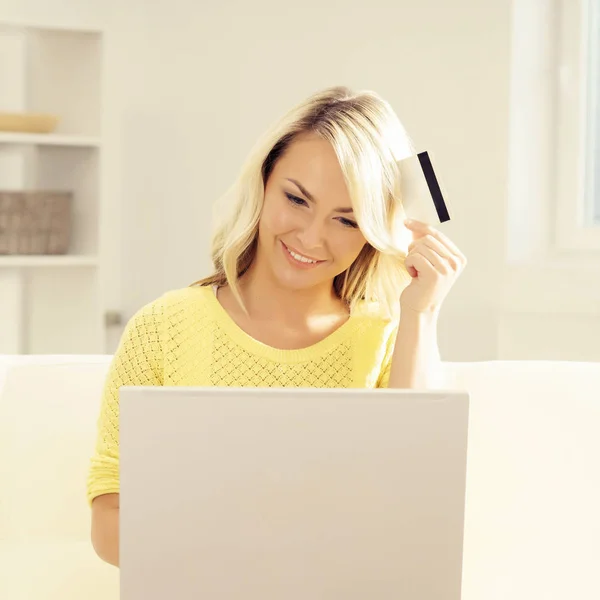 Mujer joven con laptop y tarjeta de crédito — Foto de Stock