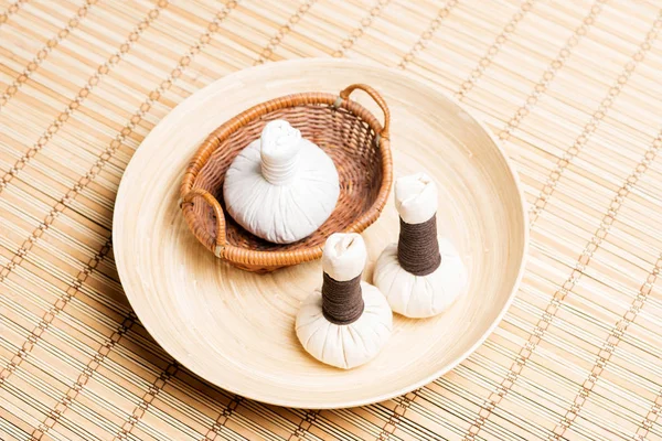 Massage bundles on plate on bamboo mat — Stock Photo, Image