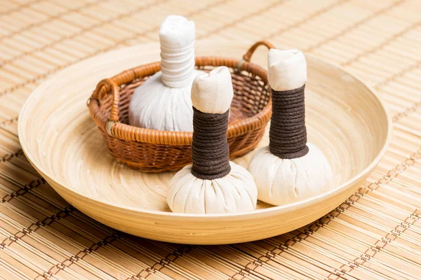 Massage bundles on plate on bamboo mat — Stock Photo, Image
