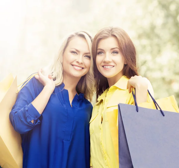 Mulheres jovens e felizes com sacos de compras — Fotografia de Stock