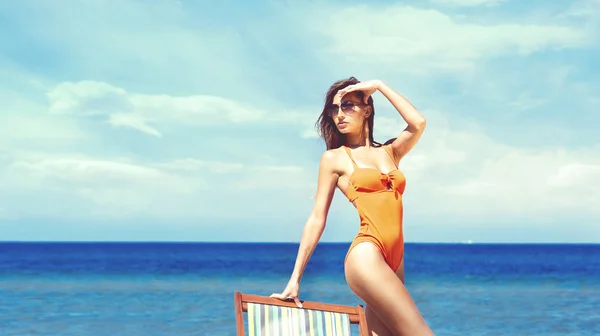 Όμορφη γυναίκα χαλαρώνοντας στην παραλία το καλοκαίρι — Φωτογραφία Αρχείου