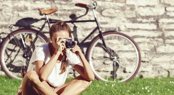 Ung kvinna sitter på gräs — Stockfoto