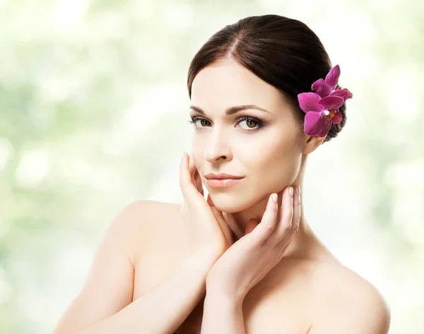 Atractiva mujer morena con orquídeas en el pelo — Foto de Stock