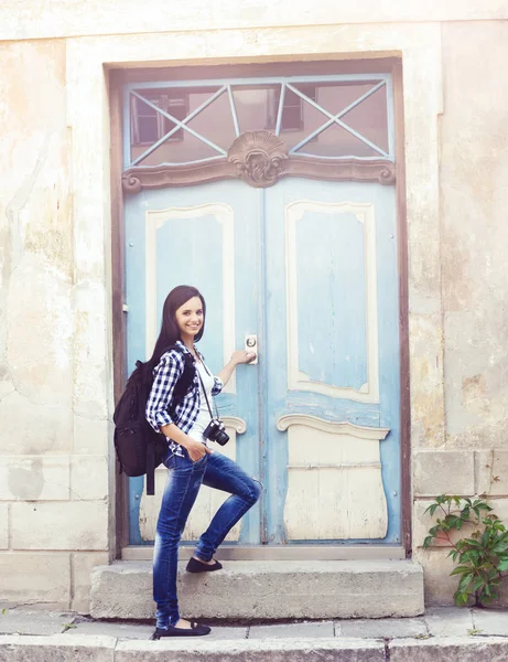 Mujer de pie contra la vieja puerta azul — Foto de Stock