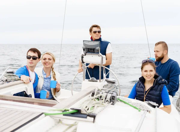 Grupp av glada vänner har en fest på en yacht — Stockfoto