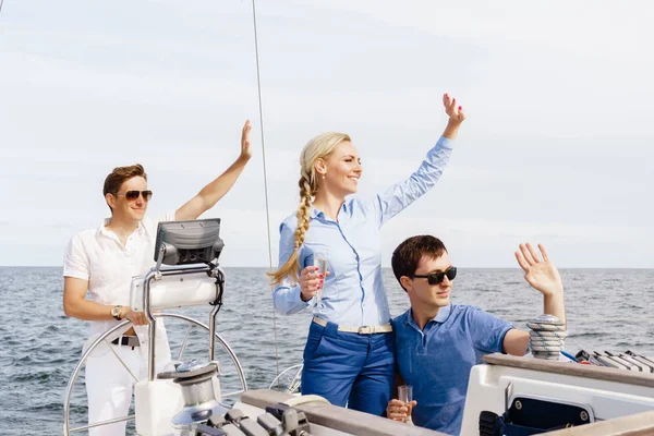 Glada och vackra par ha en vila på yacht med en kapten — Stockfoto