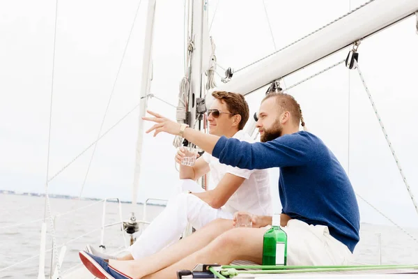 Felices amigos juntos en una cubierta de un yate — Foto de Stock