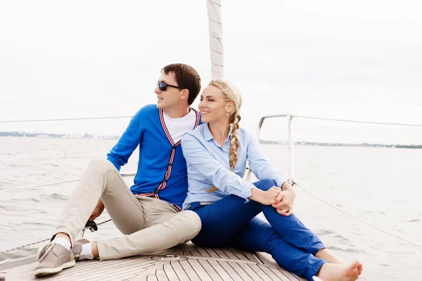 Glada och vackra unga par avkopplande på en yacht — Stockfoto