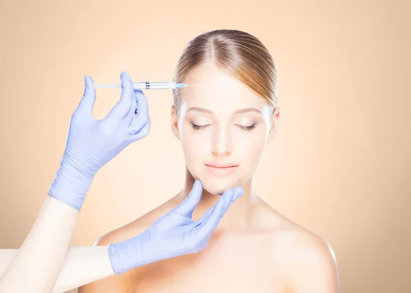 Doctor making injection into face of woman