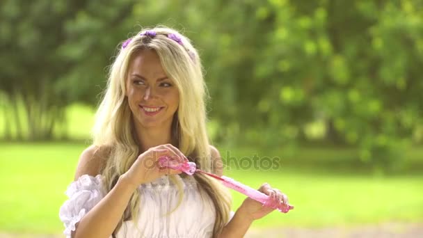 Красива жінка робить мильні бульбашки — стокове відео