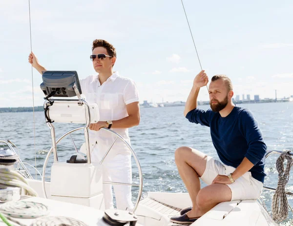 Glada vänner tillsammans på en kortlek med en yacht — Stockfoto