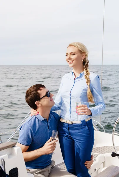 Feliz e belo casal jovem relaxante em um iate — Fotografia de Stock