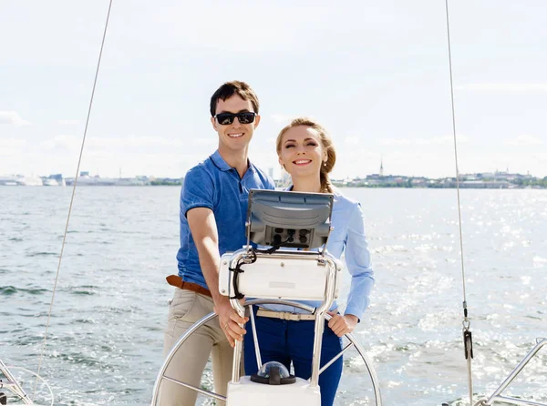 Glada och vackra unga par avkopplande på en yacht — Stockfoto