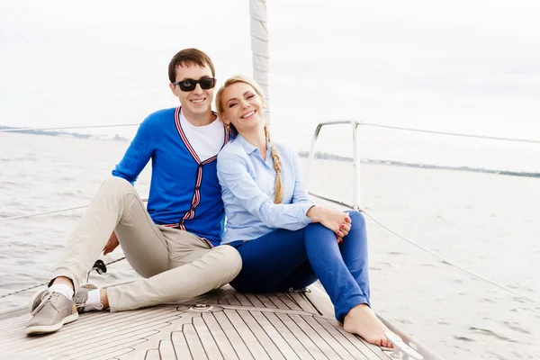 Feliz e belo casal jovem relaxante em um iate — Fotografia de Stock