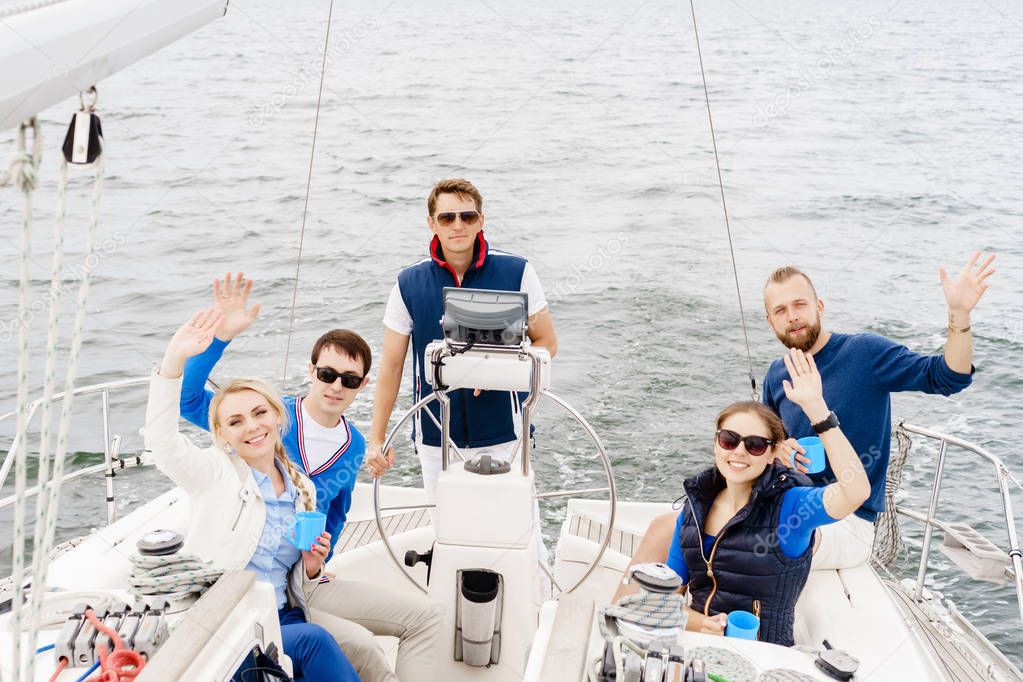 Group of happy friends having a party on a yacht