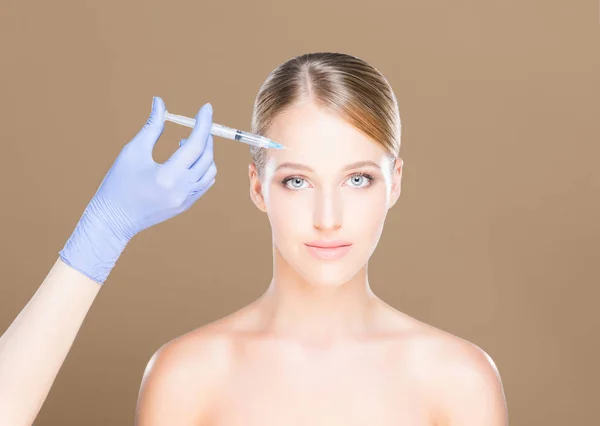 Доктор делает укол женщине в лицо — стоковое фото