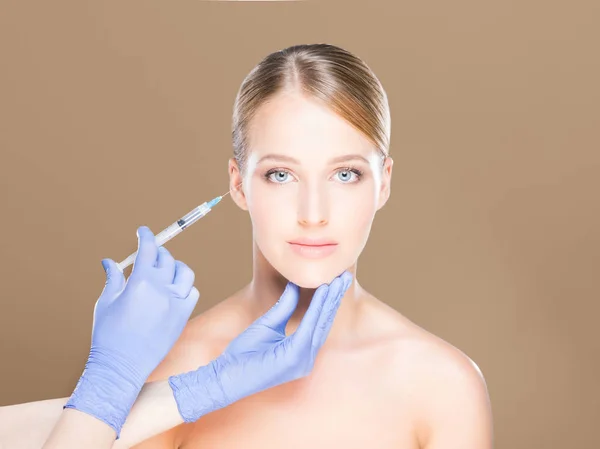 Doctor making injection into face of woman — Stock Photo, Image