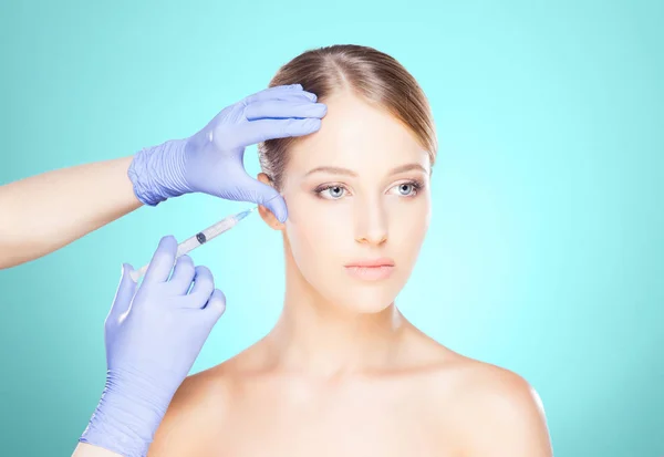 女性の顔に注射を行う医師 ロイヤリティフリーのストック写真