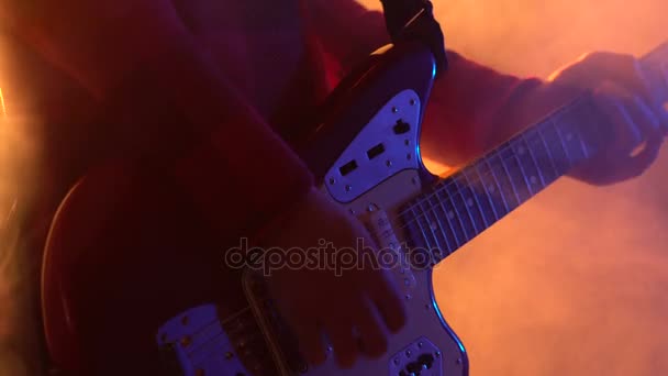 Hipster chico toca la guitarra en el escenario en el humo . — Vídeo de stock