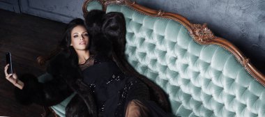 kanepe üzerinde siyah elbiseli güzel kadın