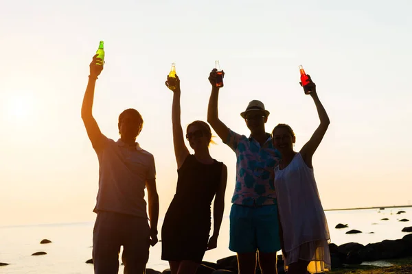 Друзья наслаждаются закатом и пьют пиво — стоковое фото
