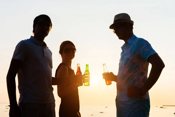 Amigos disfrutando de la puesta del sol y beber cerveza Imagen De Stock