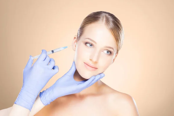 Doctor making injection into face of woman — Stock Photo, Image