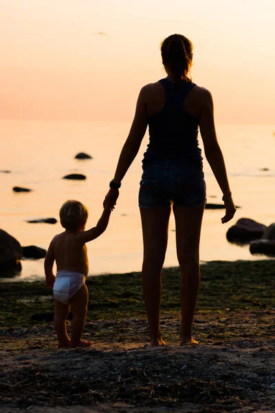 Ung mamma med baby på stranden — Stockfoto