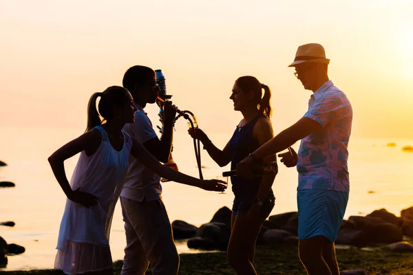 Freunde genießen Sonnenuntergang und rauchen Wasserpfeife — Stockfoto