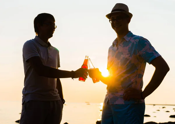 Amigos disfrutando de la puesta del sol y beber cerveza — Foto de Stock
