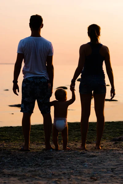 Unga föräldrar med barn på stranden — Stockfoto