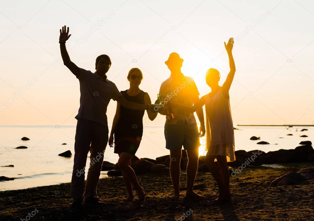 friends enjoying sunset and drinking beer