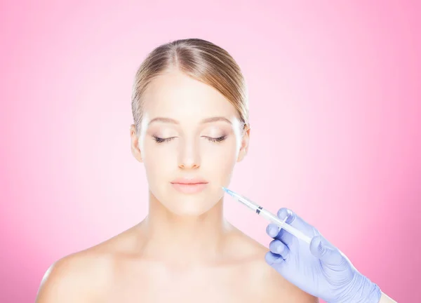 Dokter maken van injectie in gezicht van vrouw — Stockfoto