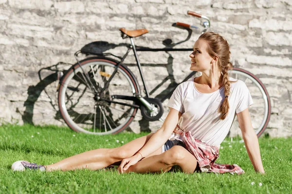 Junge Frau sitzt auf Gras — Stockfoto
