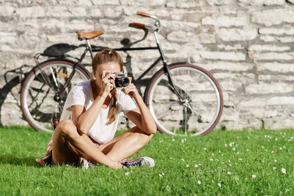 Молодая женщина сидит на траве Лицензионные Стоковые Изображения