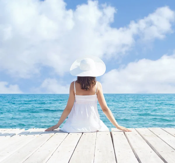 Ahşap iskele üzerinde beyaz elbiseli kadın — Stok fotoğraf