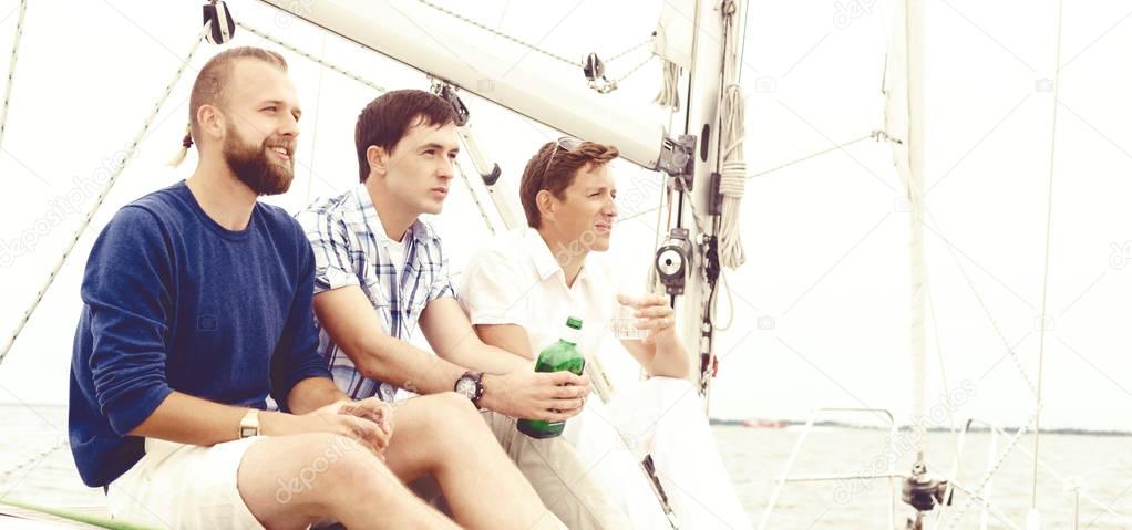 friends sitting on yacht and drinking