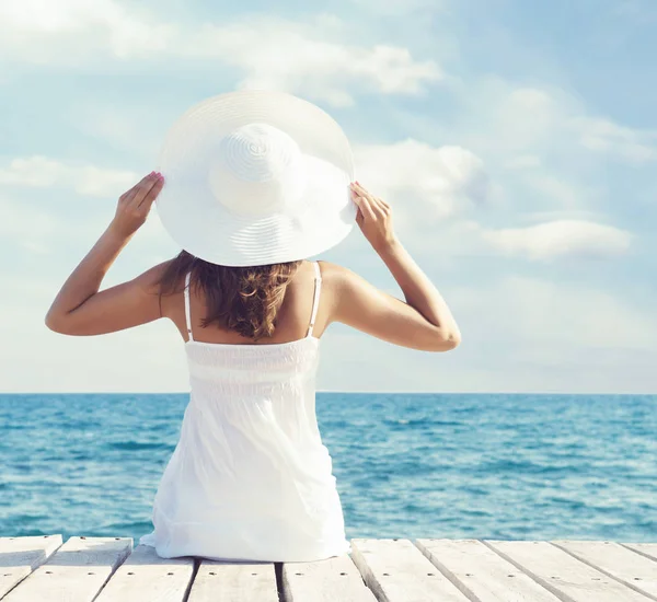 Vrouw in witte jurk op houten pier — Stockfoto