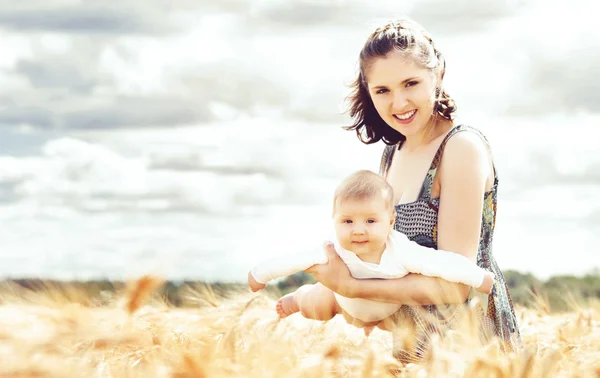 Femme avec bébé dans le champ — Photo