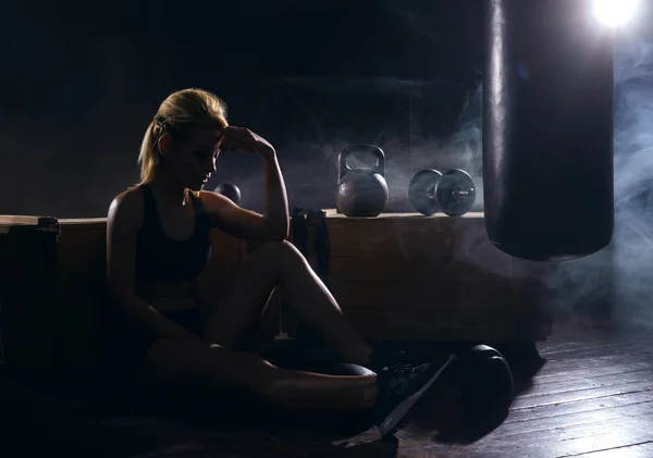Kvinna efter träningspass i mörka gym — Stockfoto