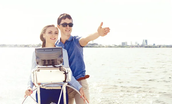 Young couple steering yacht — Stock Photo, Image