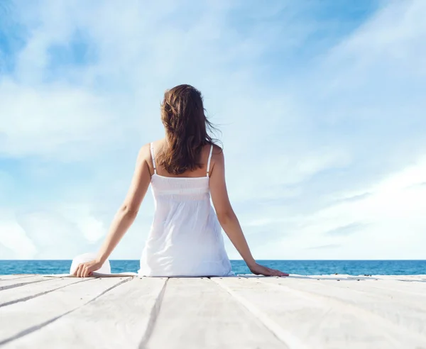 Mujer en vestido blanco en muelle de madera — Foto de Stock