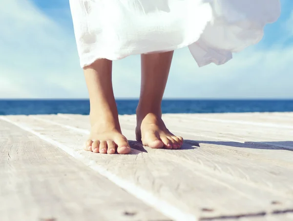 Vrouwelijke benen op houten pier — Stockfoto