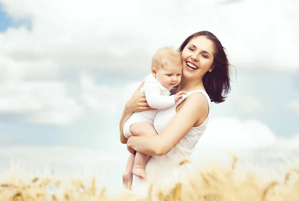 Vrouw met baby baby in veld — Stockfoto