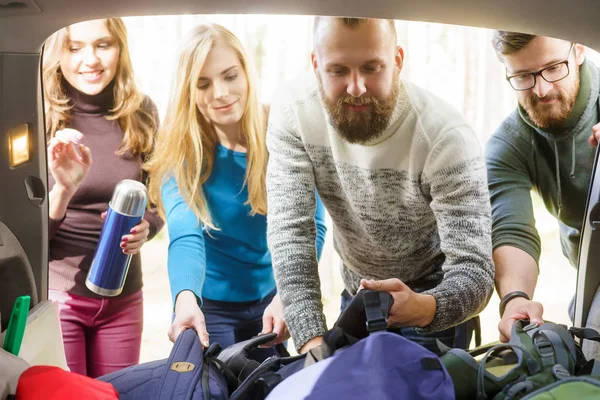 Ystävät ottavat reppuja autosta — kuvapankkivalokuva