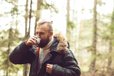 Adam sırt çantası termos çay içme ile